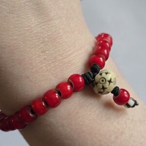Beaded bracelet red stretch off white color carved focal bead